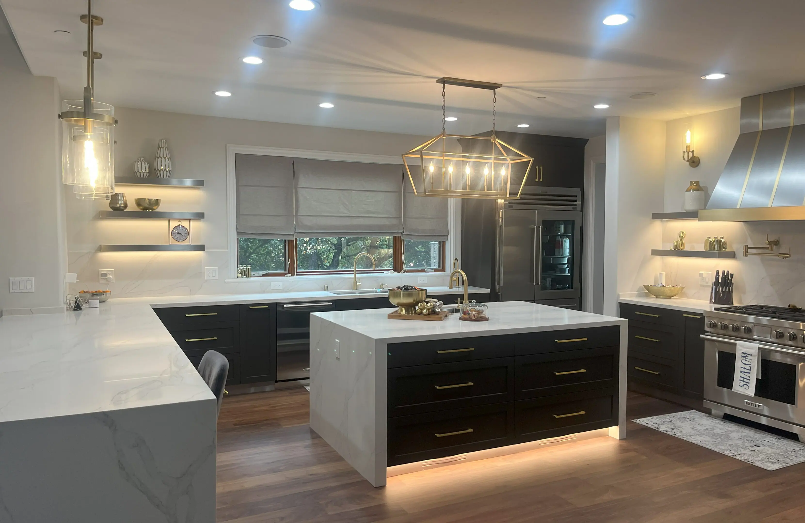Modern kitchen island in Los Altos Hills home with ebony drawers and gold chandelier